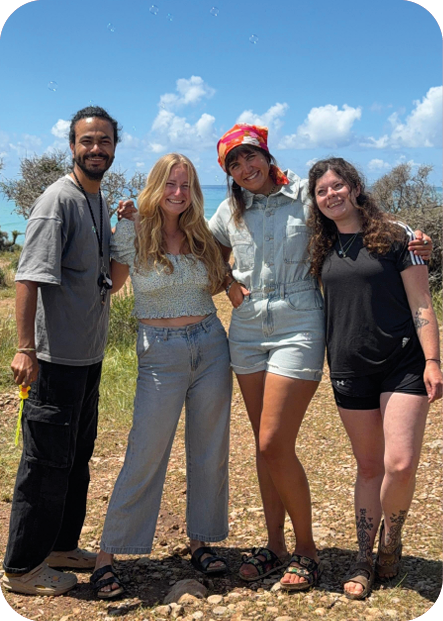 Vier Vanlife-Freunde Arm in Arm am Meer