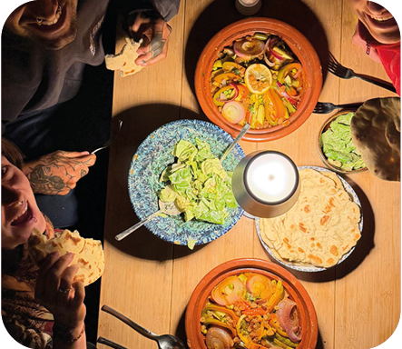 Tajine, Salat und frisches Brot auf einem Holztisch