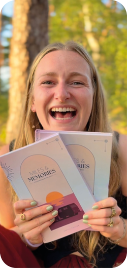 Lena, creator of Miles & Memories, holding the journals